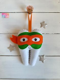 a toothbrush holder with a green and orange mask hanging from it's side