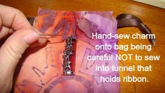 a person is holding a piece of fabric with a sewing needle in it and the words, hand sew charm onto bag being careful not to sew into tunnel that holds ribbon