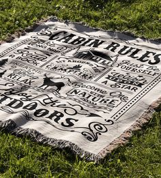 a blanket that is laying on the ground in the grass with words written across it