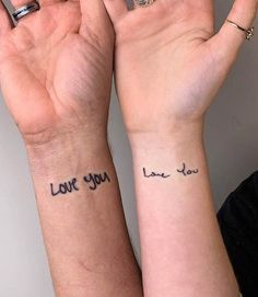 two people with matching tattoos on their arms and wrist saying i love you in cursive writing