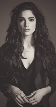 a black and white photo of a woman with long dark hair, wearing a jacket