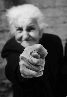 an old woman pointing her finger at the camera