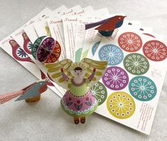 several colorful paper cut outs with birds and flowers on them next to eachother