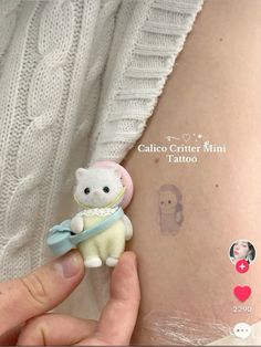 a person holding a small teddy bear in their left arm and tattoo on the back