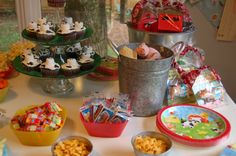 a table topped with lots of cupcakes and other items on top of it