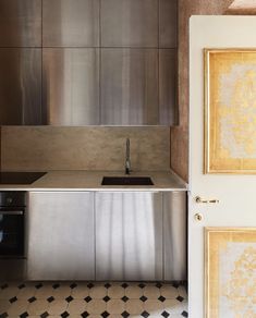 a kitchen with stainless steel cabinets and a black stove top oven next to a sink