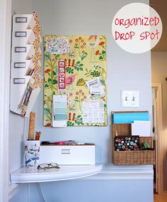 an organized drop spot on the wall above a desk with drawers and file folders