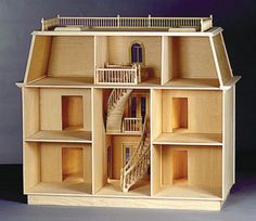 a wooden doll house with stairs and balconies