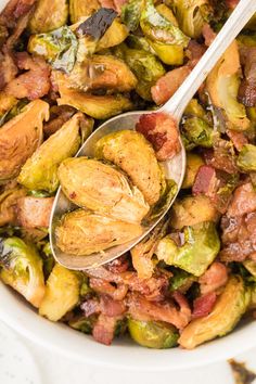 a bowl full of brussel sprouts and bacon with a spoon in it