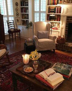 a living room filled with furniture and a fire place in front of a book shelf