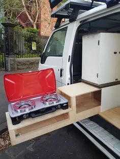 a white van with its doors open and stoves in the back