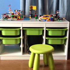 a green stool sitting next to a lego table