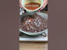 someone is pouring sauce into a bowl on top of a stove with food in it