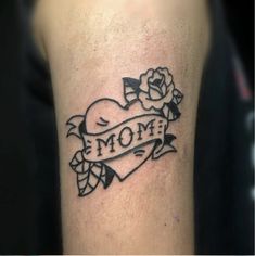 a tattoo with the word mom written on it and a rose in the middle is shown