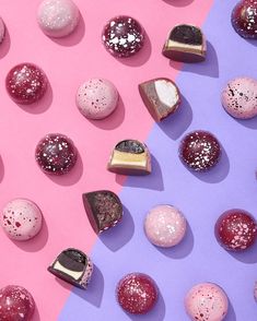 several different types of chocolates on a pink and purple background