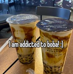 two iced coffees sitting on top of a table with the words i am added to boba