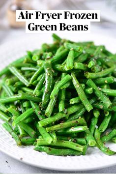 a white plate topped with green beans covered in seasoning