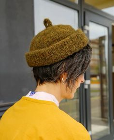 a woman wearing a yellow shirt and a brown hat