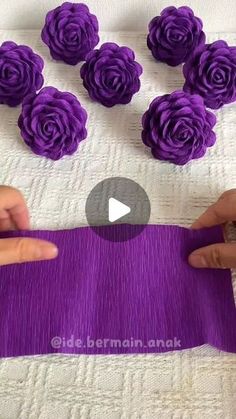 someone is making purple flowers out of yarn