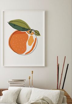 an orange print hangs on the wall above a white couch