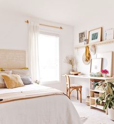 a bedroom with white walls and lots of pictures on the wall