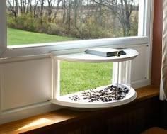 a window sill with a book on top of it in front of a grassy field