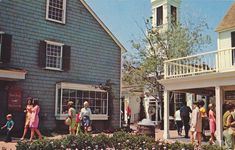 several people are walking around in front of some houses