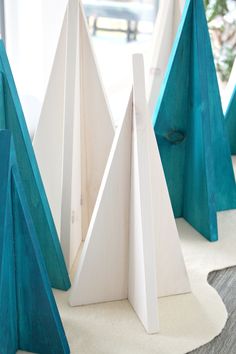 three blue and white pieces of wood sitting on top of a table