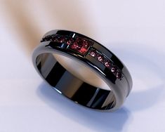 a black ring with red diamonds on it