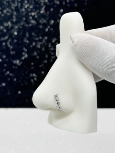 a white mannequin head with a diamond ring on it