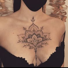 a woman's chest with an intricate tattoo on it