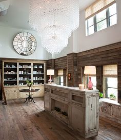 a large room with wooden floors and chandelier hanging from the ceiling above it