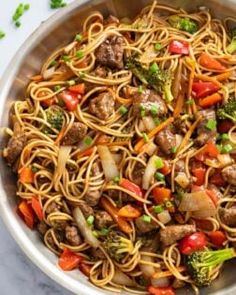 a bowl filled with noodles, meat and veggies