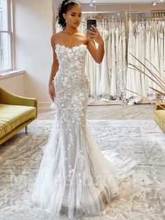 a woman is taking a selfie in her wedding dress at the bridal shop