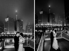 a bride and groom standing on a balcony in front of the city skyline at night