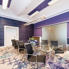 a glass table and chairs in a room with purple walls, blue carpet and white ceiling