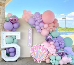 the balloon arch is decorated with pastel colors