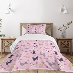 a bed covered in pink and black cats