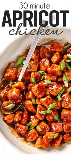 a white bowl filled with chicken covered in sauce and garnished with green onions