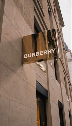 a burberry sign hanging on the side of a building with an awning