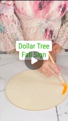 a woman is making a paper tree with a paintbrush and some writing on it