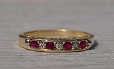 The Sovana: Yellow Gold Ruby and Diamond Band. The ring features alternating vivid red round brilliant cut rubies with alternating round brilliant cut diamonds across the center of a channel. The ring features filigree in the through finger view featuring the words I LOVE YOU only visible from the side. The ring is beautifully crafted in yellow gold and is currently a finger size 7 1/2 yet can be adjusted to any finger size for an additional charge on request. Love this piece, but don't have the Ruby Wedding Band With Engagement Ring, Channel Set Ruby Anniversary Rings, Red Rings With Diamond Accents For Anniversary, Red Diamond Wedding Ring With Accents, Red Ruby Ring With Single Cut Diamonds For Wedding, Red Wedding Rings With Single Cut Diamonds, Red Single Cut Diamond Wedding Rings, Red Ring With Diamond Accents For Promise, Wedding Ruby Ring Channel Set Round Cut