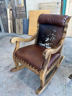 a wooden rocking chair with brown leather upholstered on it's seat and back