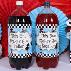 three bottles of liquid sitting on top of a table next to red and blue decorations