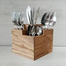 a wooden holder with silverware in it