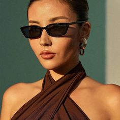 a woman wearing sunglasses and a brown dress