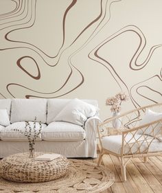 a living room with a white couch, chair and coffee table in front of a wall mural