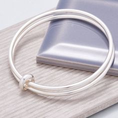 Introducing the Eclipse Double Bangle: a captivating piece of jewellery that captures the essence of a solar eclipse - a rare moment of enchantment that reminds us of the beauty in imperfect progress. Crafted for women who appreciate simple style & elegance, this handmade double bangle features asymmetrical Eclipse loop, a unique design element that adds a touch of magic to your everyday. Feel the gentle sway of the silver loop as it gracefully moves against the weight of the bangles, echoing the rhythms of your day. The Eclipse loop, with its organic and asymmetric form, emulates the wonder of a partial eclipse - an embodiment of perfection found in asymmetry. Each piece bears a hallmark, a symbol of its solid, premium-quality weight, ensuring that you wear nothing but the best. Choose fr Sunflower Necklace Silver, Stacking Bangles, Silver Gold Jewelry, Silver Jewelry Handmade, Sterling Silver Bangles, Gifts Birthday, Bangle Set, Sea Glass Jewelry, Gifts Christmas