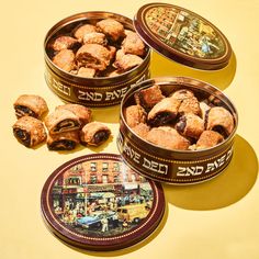 three tins filled with pastries sitting on top of a yellow countertop next to each other