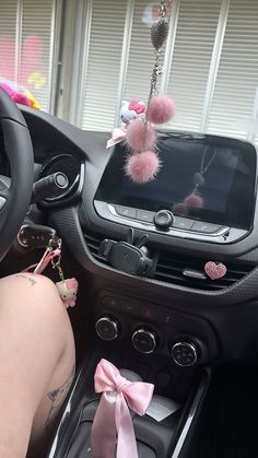 a car dashboard with a pink pom - pom attached to the dash board